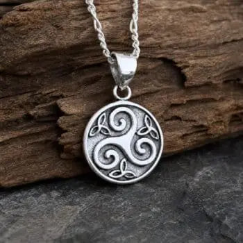 an image of a small Sterling Triskelion-Trinity Pendant. The pendant is round and in the center is the Triskele Celtic Symbol meaning three legged and in the small spaced around the Triskele symbol are three small Triquetra or Trinity Knots. There is oxidation on the background of the circle and the triskele is raised up a bit. The pendant height is .55 inches