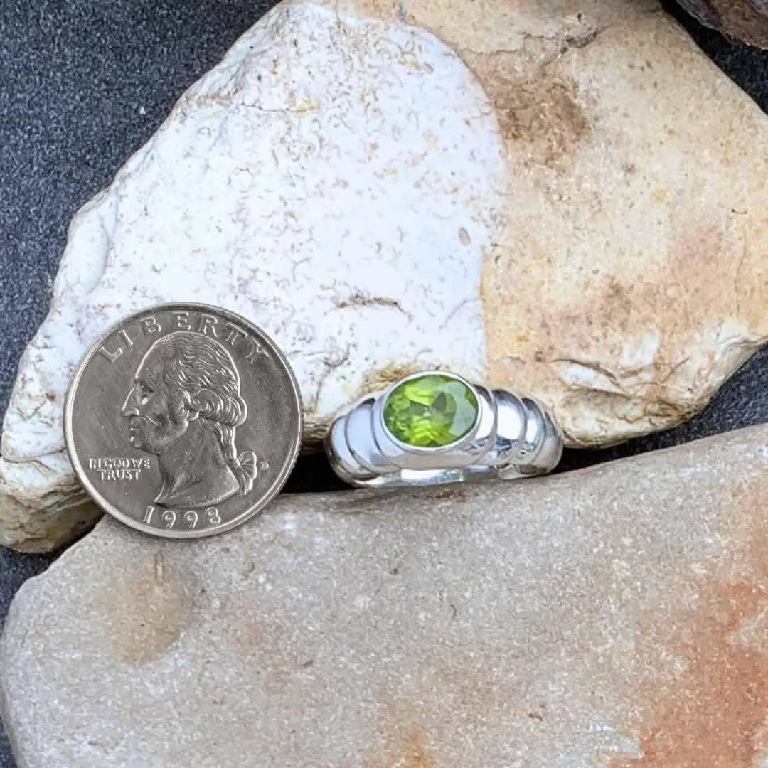 Contemporary Sterling Silver & Oval Faceted Peridot Ring Next to Quarter
