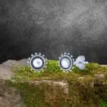 an image of a pair of Sterling Silver Bali Style Stud Earrings with a plain round center surrounded by a silver beaded frame and then a circle of little beads almost like petals on a flower