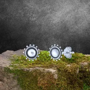 an image of a pair of Sterling Silver Bali Style Stud Earrings with a plain round center surrounded by a silver beaded frame and then a circle of little beads almost like petals on a flower
