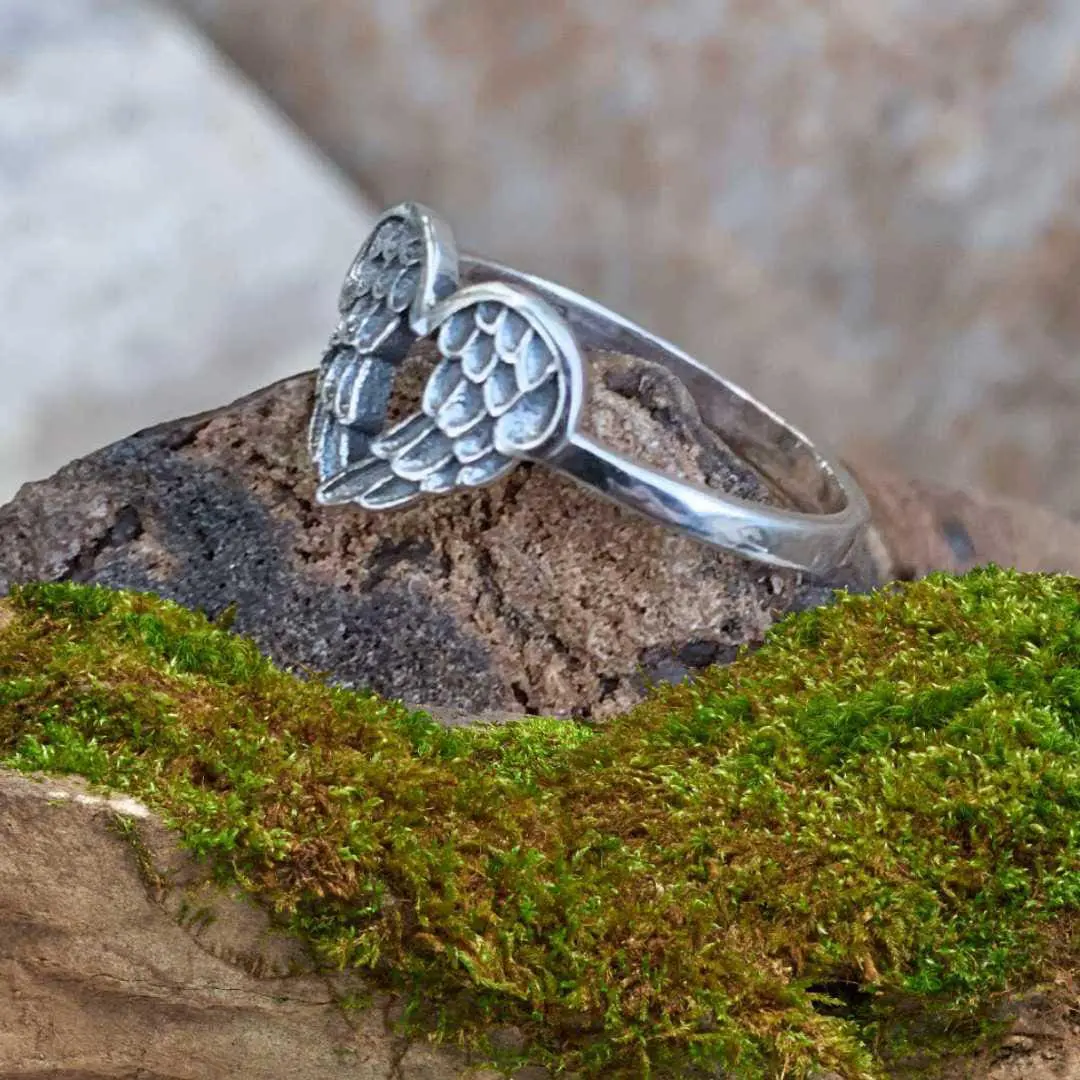 an image of a side view of a sterling silver ring of two angel wings forming a heart