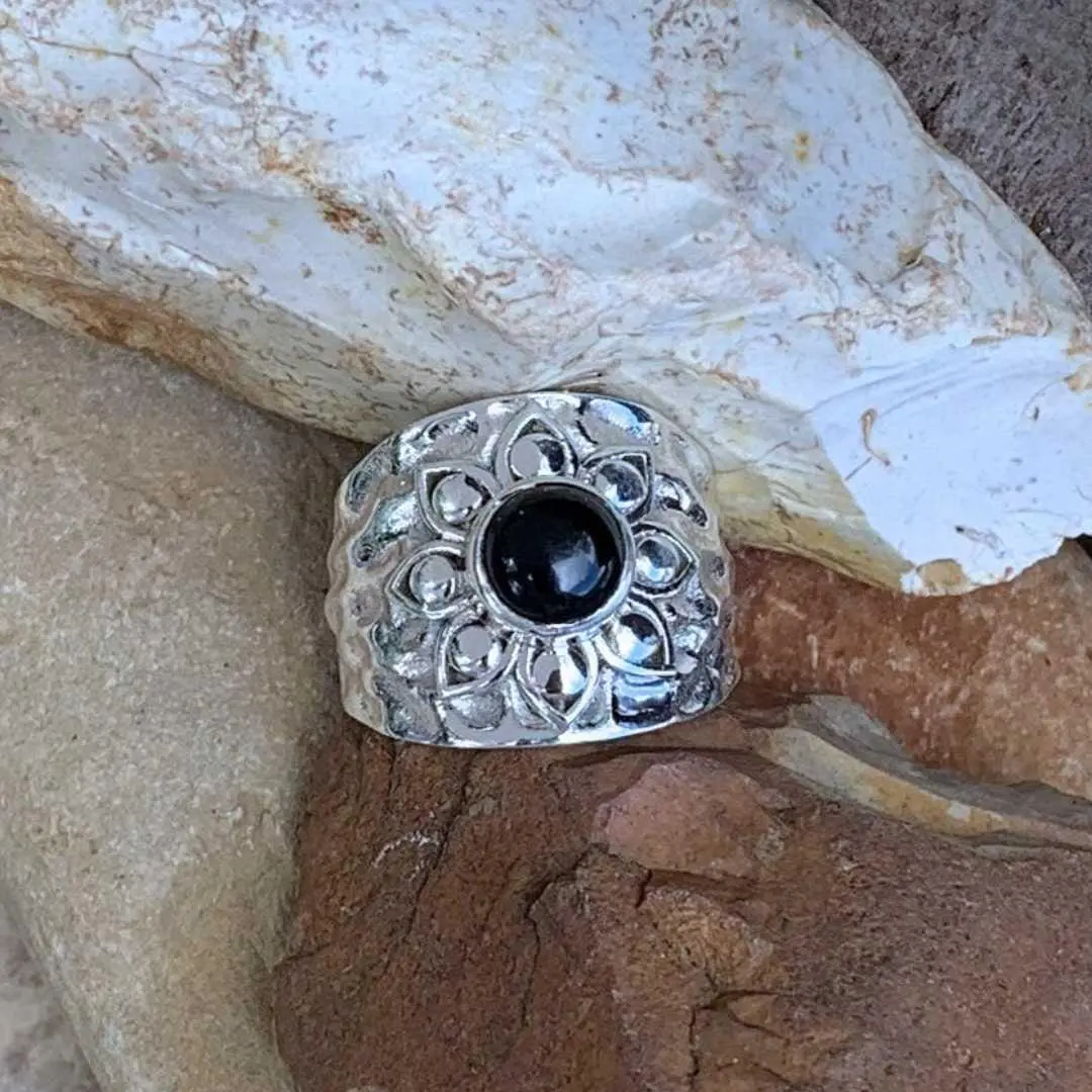 an image of a wide Sterling Silver Band style ring with a lotus design on top with a round black onyx stone in the center
