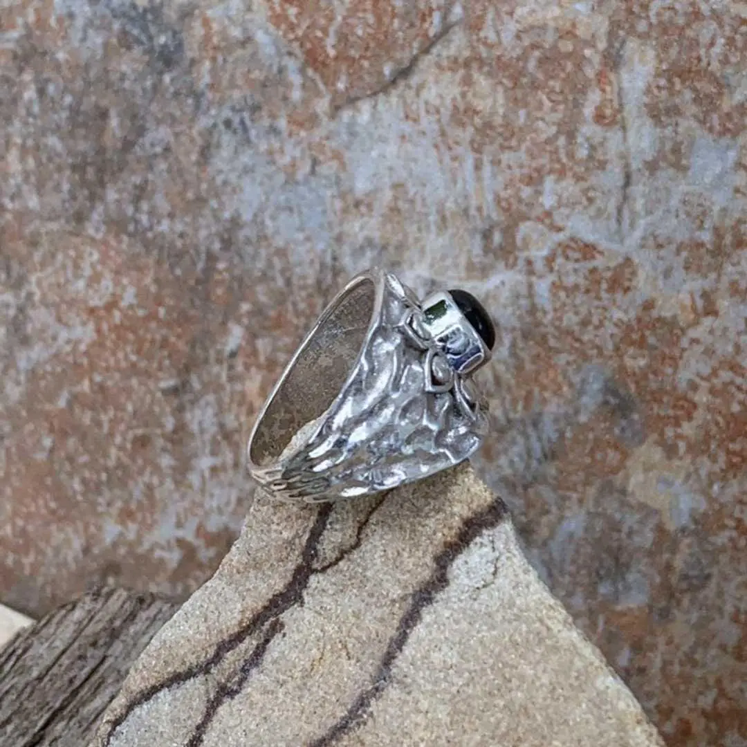 an image of a wide Sterling Silver Band style ring with a lotus design on top with a round black onyx stone in the center