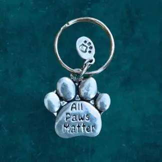 A pewter Keychain that is a paw that says All Paws Matter