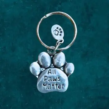 A pewter Keychain that is a paw that says All Paws Matter