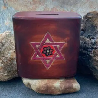 an image of a 4.50 x 2.50 x 4.25 inch brown wood box with a burgundy shaded star of David on the front and a coin slot on top. The box has a secret sliding panel on the bottom to open and close it.