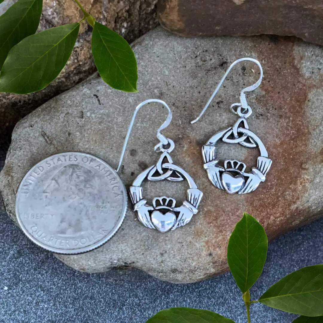 n image of a pair of Sterling Silver Dangle Claddagh Earrings with Triquetra Celtic Knot next to a quarter