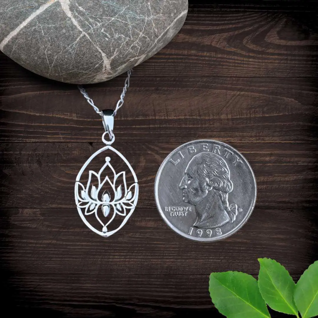 an image of a Sterling Silver Full Lotus Marquise Pendant with an open design inside the marquise shape. This image shows the pendant next to a quarter