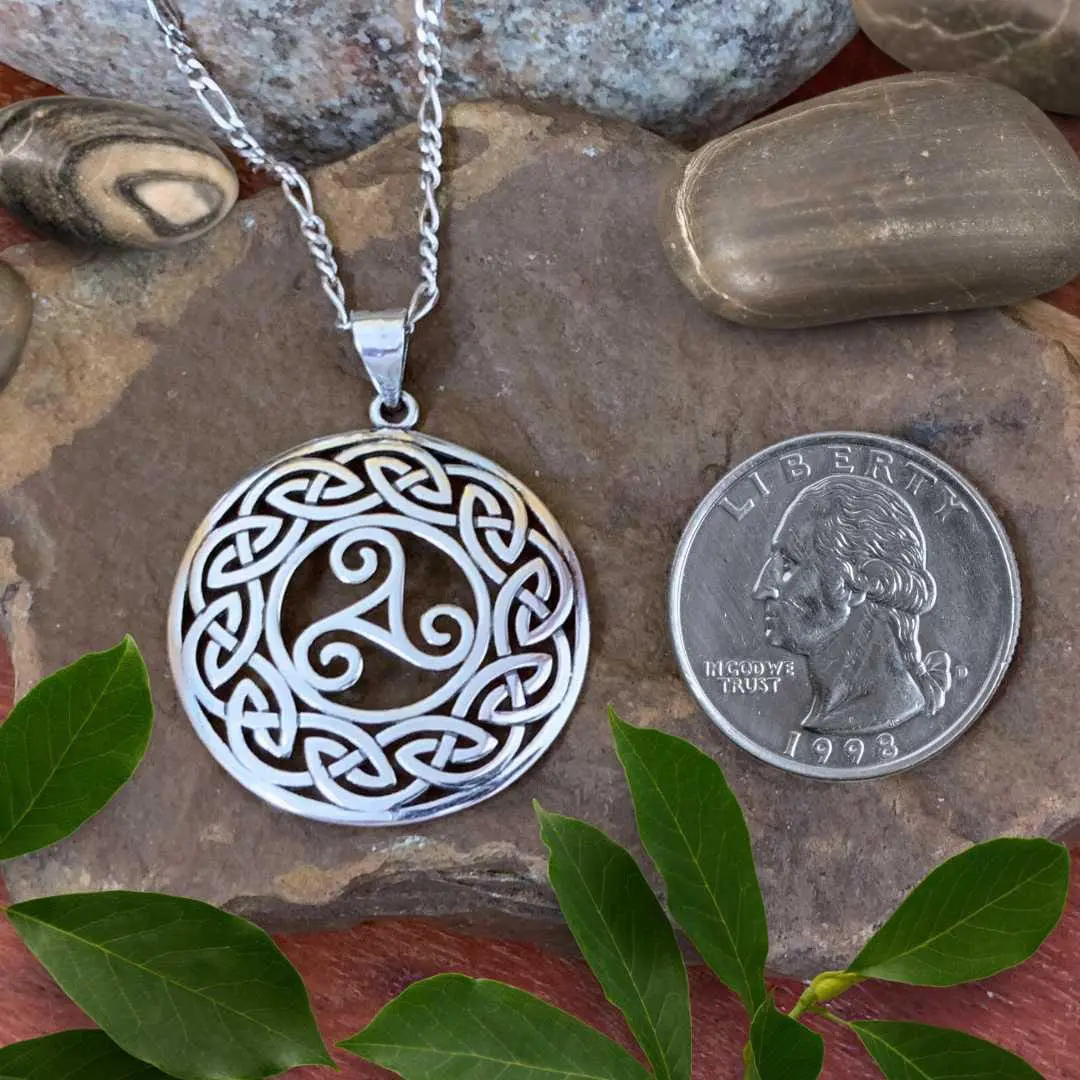 an image of a Triskelion in Celtic Knots Sterling Silver Pendant next to a quarter
