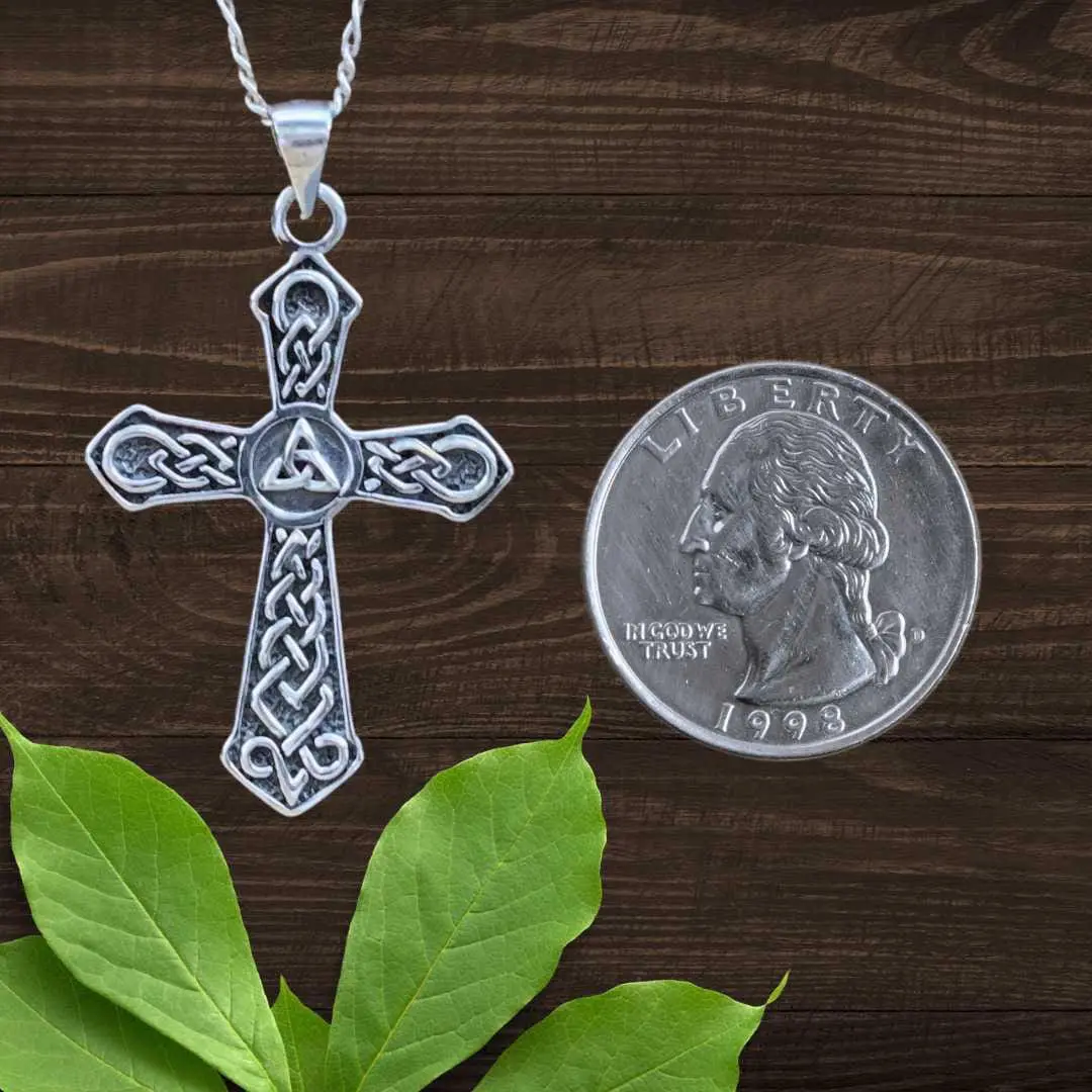 an image of a Sterling Silver Triquetra Knot Celtic Cross Pendant next to a quarter