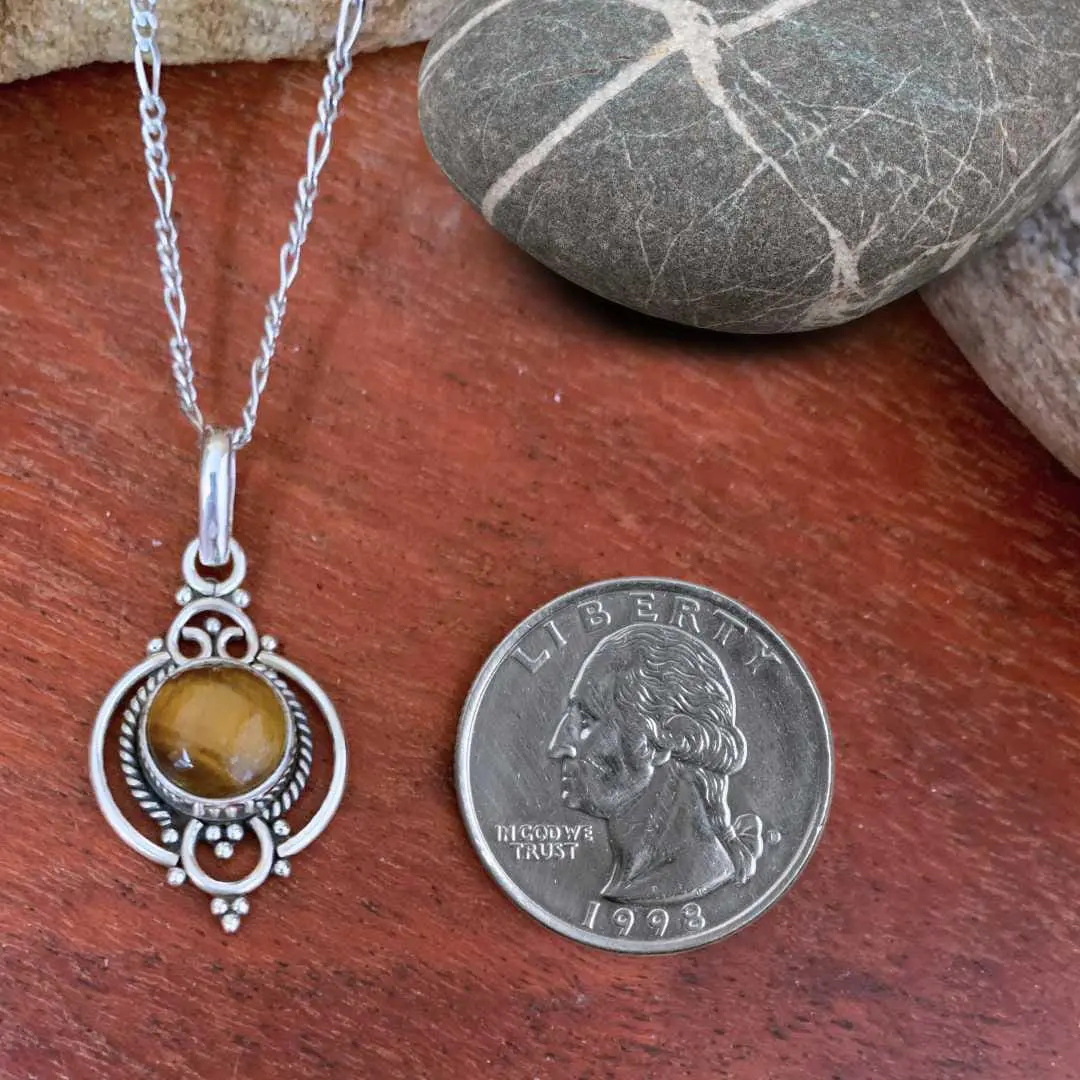 an image of a Feminine Tiger's Eye and Sterling Silver Pendant next to a quarter