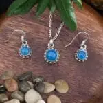an image of a Sterling Silver and Blue Chalcedony Pendant and Earrings Set with a dainty round pendant and matching slightly smaller round dangle earrings.