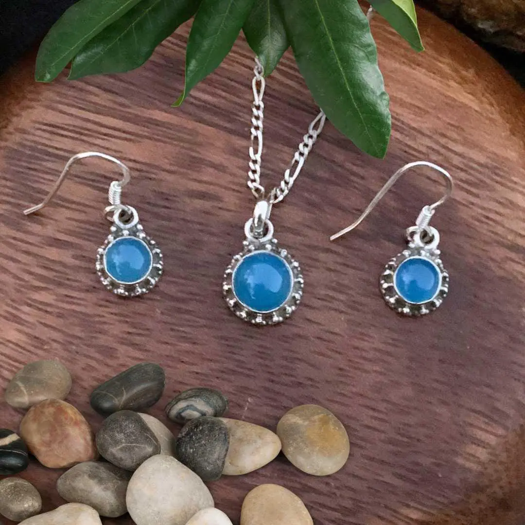 an image of a Sterling Silver and Blue Chalcedony Pendant and Earrings Set with a dainty round pendant and matching slightly smaller round dangle earrings.