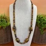 an image of a beaded tiger's eye gemstone necklace featuring four large barrel shaped beads with smaller round beads.