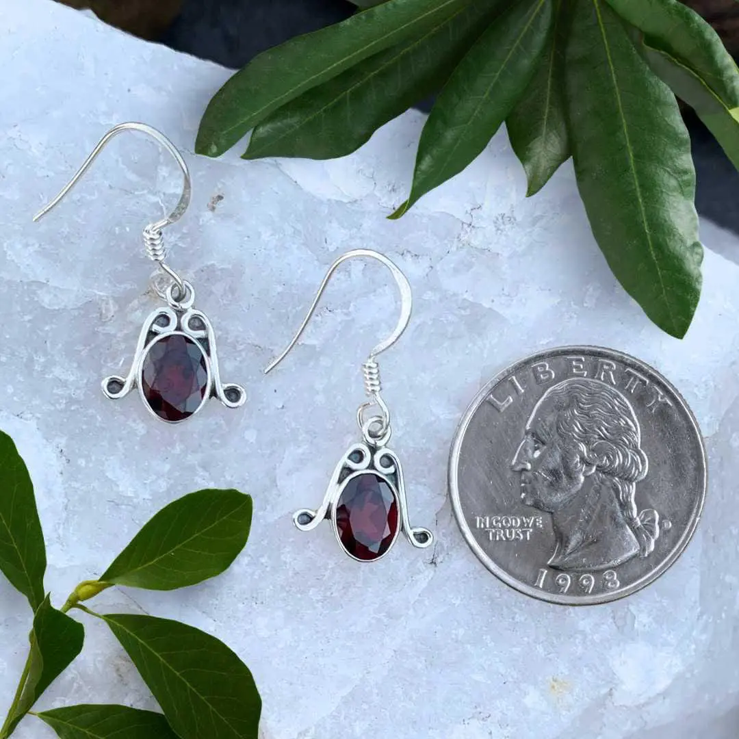 an image of a pair of Oval Faceted Garnet and Sterling Silver Earrings next to a quarter