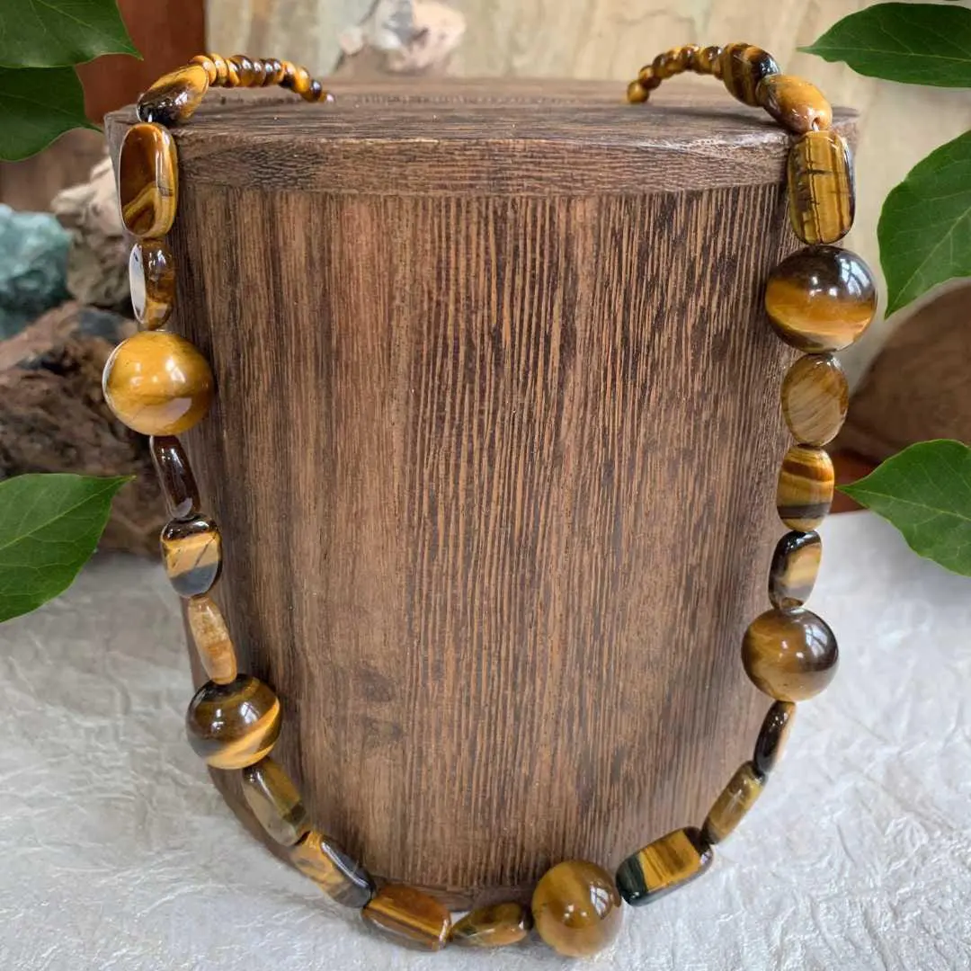 an image of a tiger's eye gemstone beaded necklace featuring large round beads mixed with a variety of other shapes.