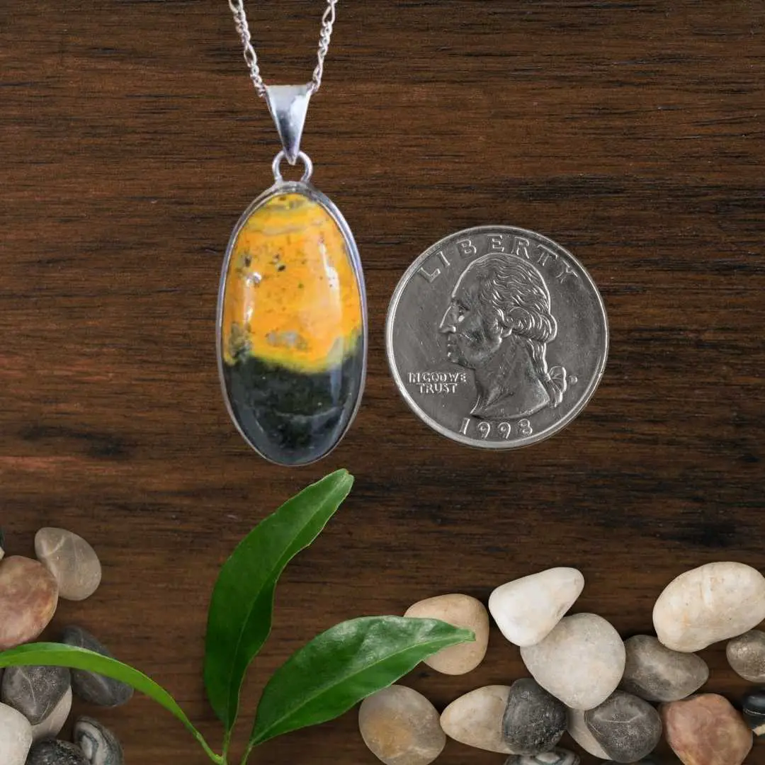 an image of a Sterling Silver and Oval Bumblebee Jasper Pendant next to a quarter