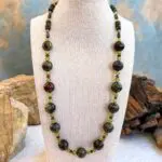 an image of a Dragon Blood Jasper with Garnet and Peridot Necklace with large 12 mm round dragon blood jasper beads and smaller peridot and garnet accents as well as small barrell and rondelle dragon blood jasper working around the top of the neck. FInished with sterling silver lobster clasp