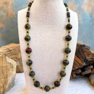 an image of a Dragon Blood Jasper with Garnet and Peridot Necklace with large 12 mm round dragon blood jasper beads and smaller peridot and garnet accents as well as small barrell and rondelle dragon blood jasper working around the top of the neck. FInished with sterling silver lobster clasp