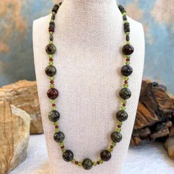 an image of a Dragon Blood Jasper with Garnet and Peridot Necklace with large 12 mm round dragon blood jasper beads and smaller peridot and garnet accents as well as small barrell and rondelle dragon blood jasper working around the top of the neck. FInished with sterling silver lobster clasp