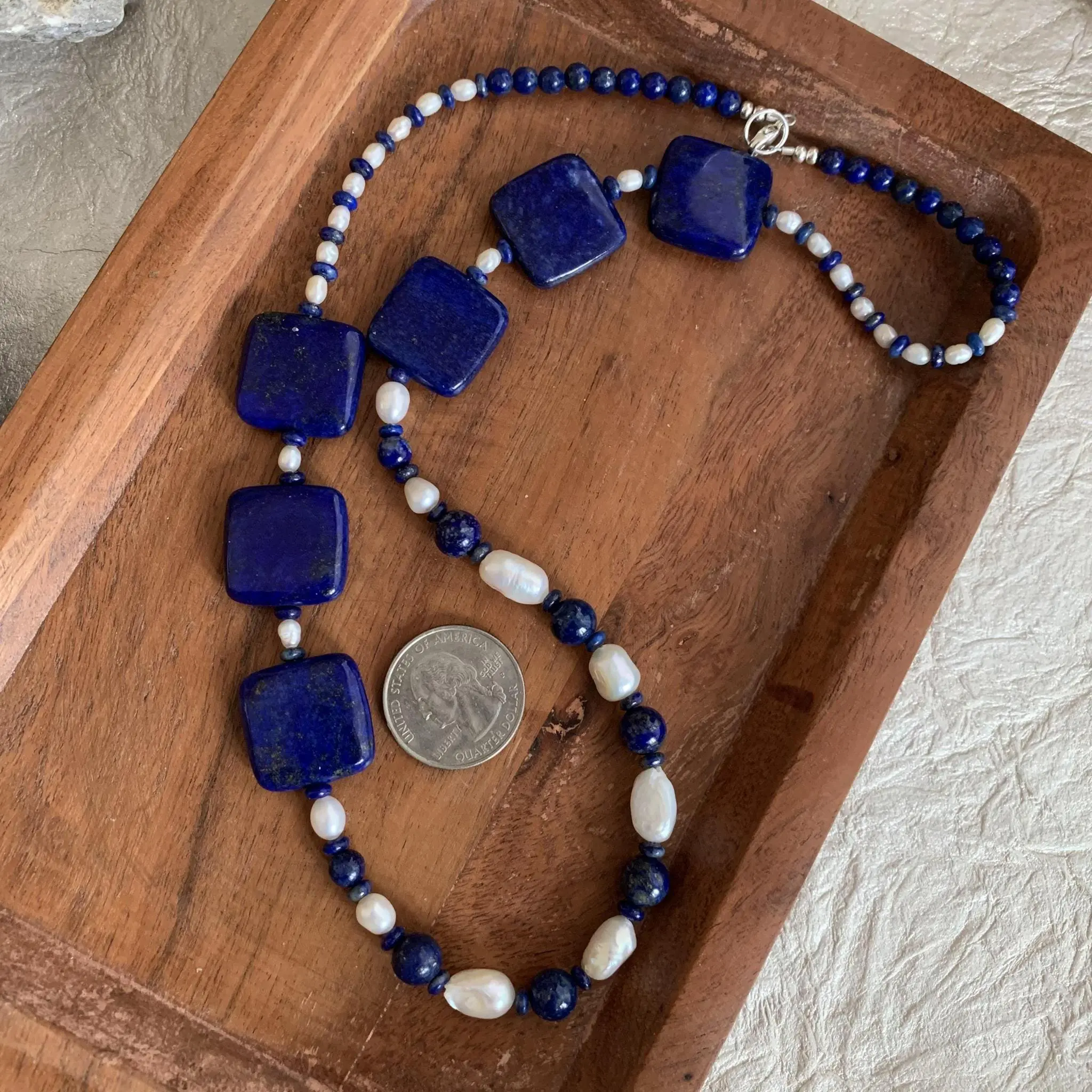 an image of a Lapis Lazuli and Pearls Statement Necklace next to a quarter