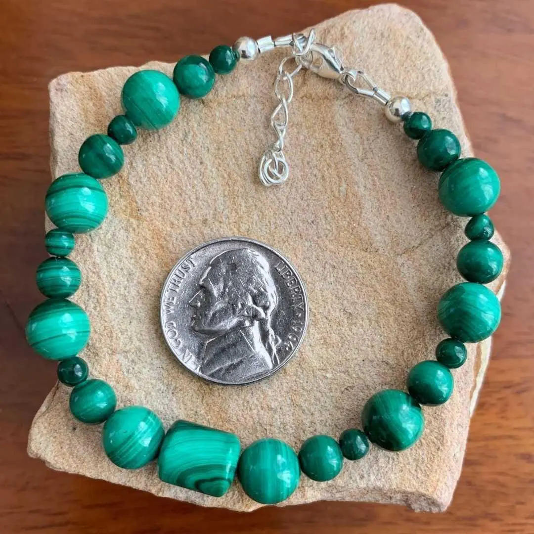 an image of a Assorted Round and Barrel Beaded Malachite Bracelet with sterling silver beads and lobster clasp on ends next to a nickel