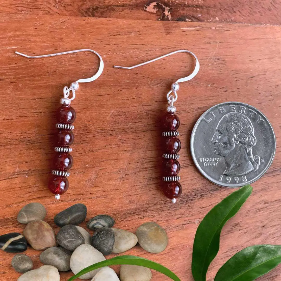 an image of a pair of Stacked Round Garnet Beads with Sterling Silver Earrings next to a quarter