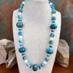 an image of a Mixed Apatite with Mother of Pearl Beaded Necklace featuring 18mm faceted rondelle apatite beads mixed with round and heishi shaped blue apatite beads with round mother of pearl beads.