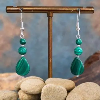 an image of a pair of Teardrop Malachite and Sterling Silver Earrings featuring a teardrop shaped malachite bead at the bottom, then a round smooth malachite bead above it with a smaller one on the ery top. The malachite beads are all separated with a 2mm sterling silver bead and hang on a sterling silver earring hook.