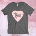 An image of a charcoal grey t-shirt with a large pink heart across the chest and a grey dachshund dog on the heart.