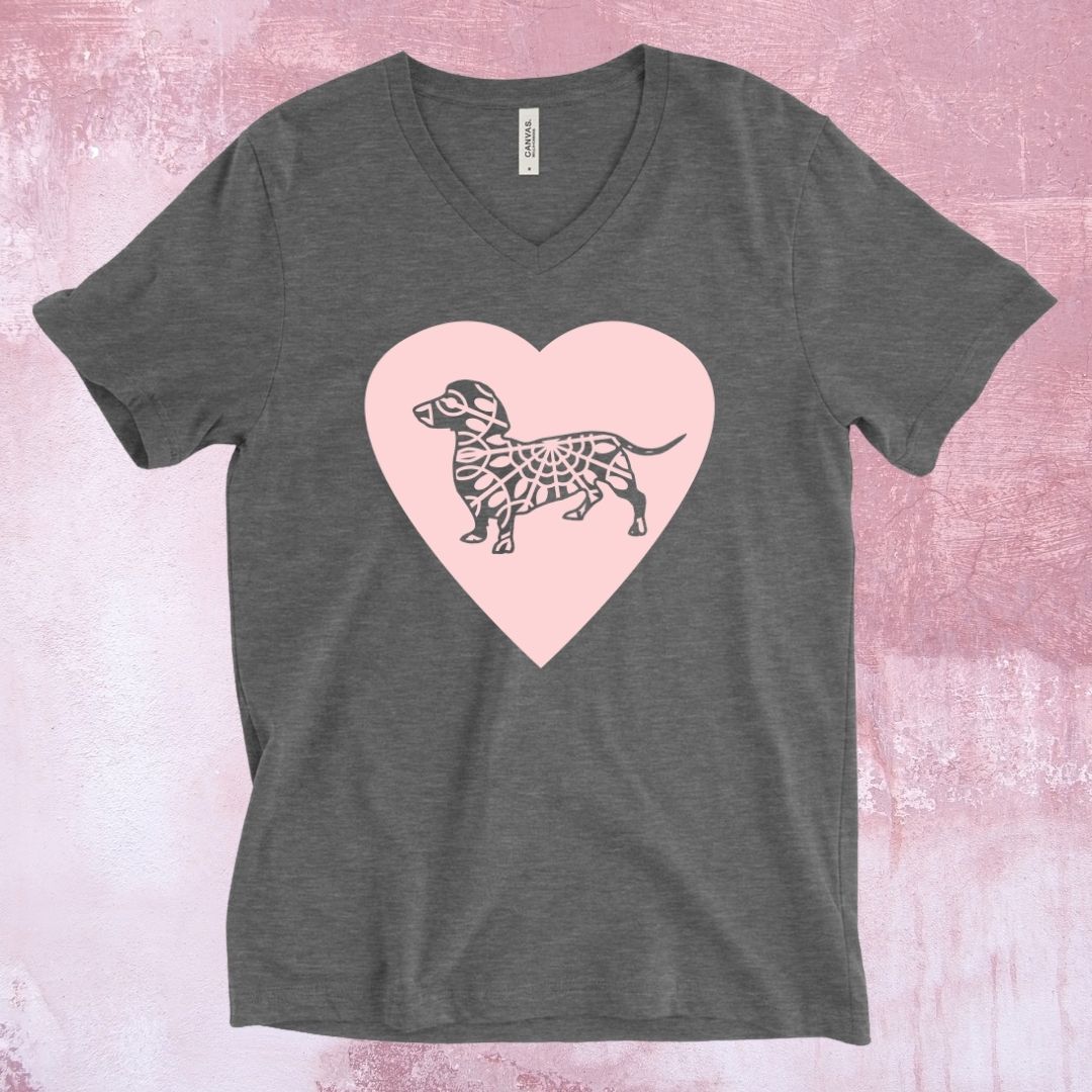 An image of a charcoal grey t-shirt with a large pink heart across the chest and a grey dachshund dog on the heart.