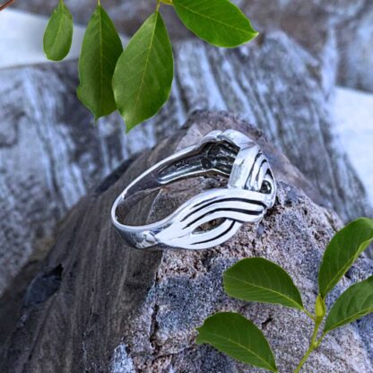 an image of a side view sterling silver ring with a design that looks like braided waves