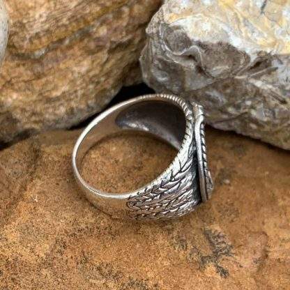 Side view of round oxidized sterling silver ring with anchor in center