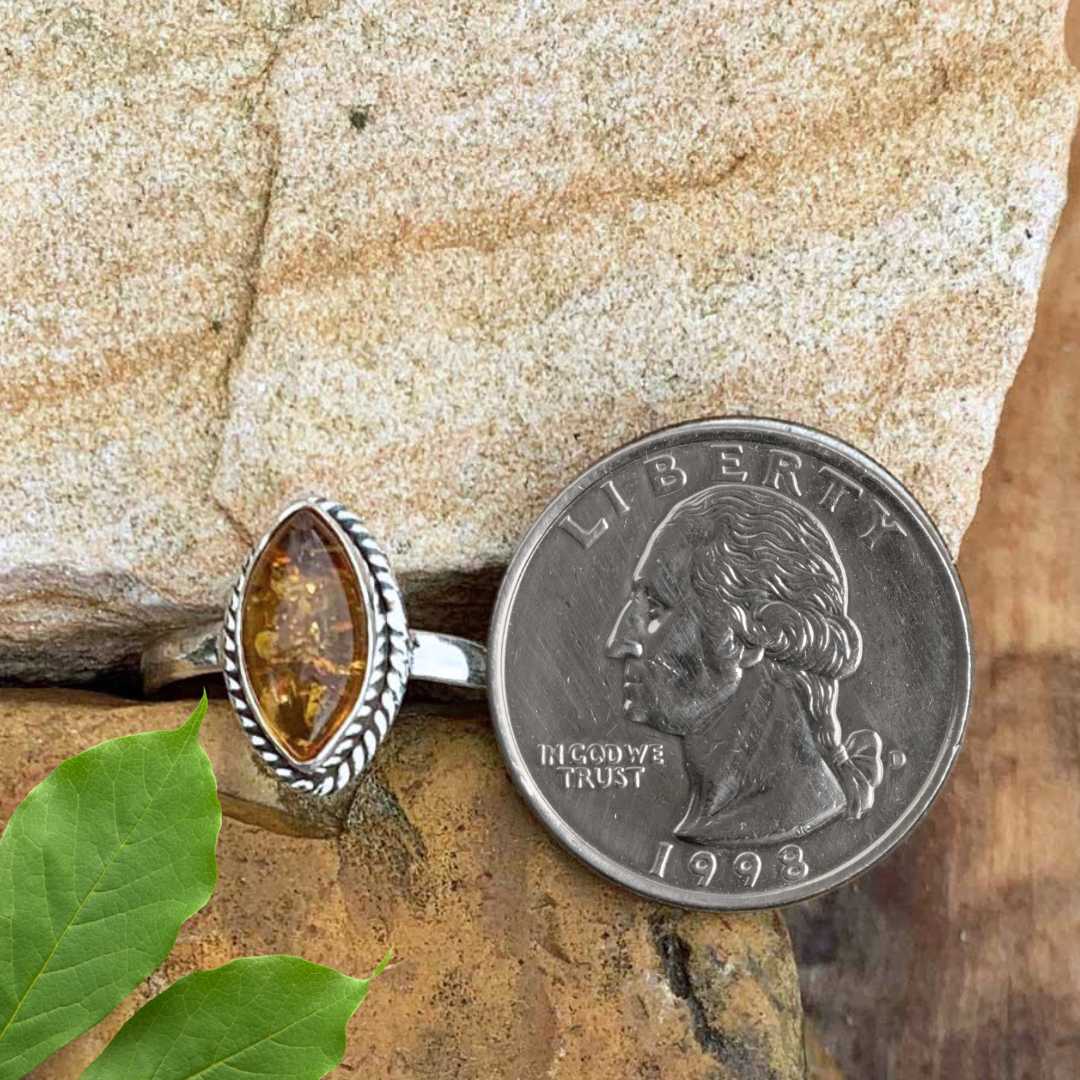 an image of a Marquise Amber and Sterling Silver Ring next to a quarter