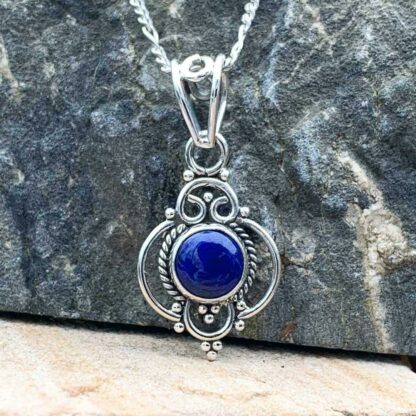 Feminine Sterling Silver pendant with round Lapis Lazuli stone in center.