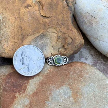 Round Sterling Silver and Peridot Dainty Ring Next to Quarter