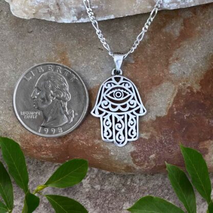 Sterling Silver Filigree Hamsa Pendant with Eye in Palm next to quarter for perspective.