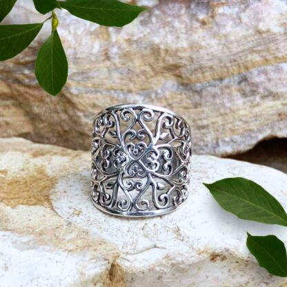 an image of what we call our Sterling Silver Fairytale Ring which is a wide filigree band consisting of swirling patterns and hearts that connect in the center