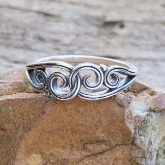 This is a picture of a feminine sterling silver ring with swirls of silver that meet on the top in the center and interlace.
