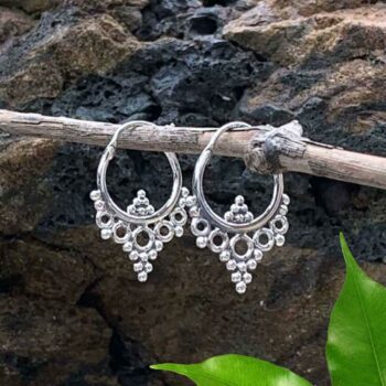 A photo of Sterling Silver Hoop Earrings with 6 little silver beads at the bottom inside of the hoop and a group of open silver circles with silver beads below the hoop going down into a point.