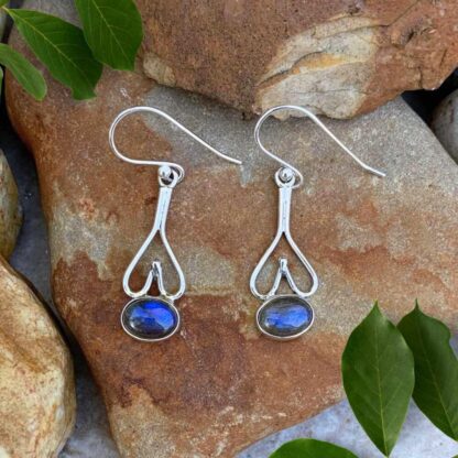 Upside down open sterling silver hearts with a horizontally placed oval labradorite gemstone at the bottom of these dangle sterling silver and labradorite earrings.