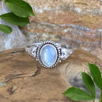 An image of our Oval Rainbow Moonstone and Sterling Silver Ring With a Heart on each side of the stone