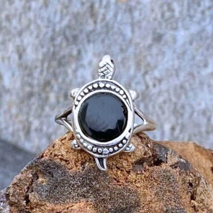 An image of a sterling silver turtle with the shell section being a round piece of black onyx gemstone