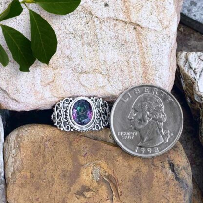 an image of an Ornate Faceted Oval Mystic Topaz and Sterling Silver Ring next to a quarter