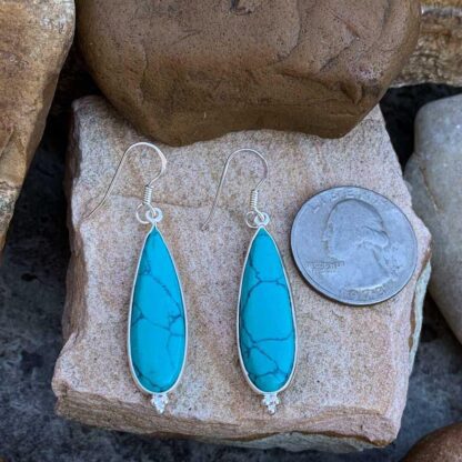 an image of a pair of Sterling Silver and Turquoise Teardrop dangling Earrings with a trio of sterling silver beads at the bottom