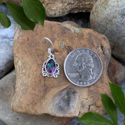 An image of our Elegant Sterling Silver Teardrop Mystic Topaz Dangle Earring that has a Total Drop: 1.06 inches x Width: .39 inches. The earring is next to a quarter for perspective