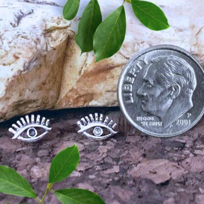 an image of a pair of Sterling Silver Eye Stud Earrings with an open area around the eyeball and eyelashes above the eye