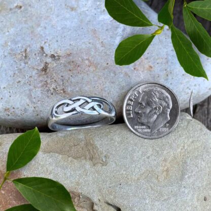 an image of a Celtic Knot Sterling Silver Band Ring next to a dime