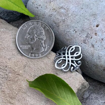 an image of a Celtic Swirl Sterling Silver Ring next to a quarter