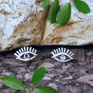an image of a pair of Sterling Silver Eye Stud Earrings with an open area around the eyeball and eyelashes above the eye